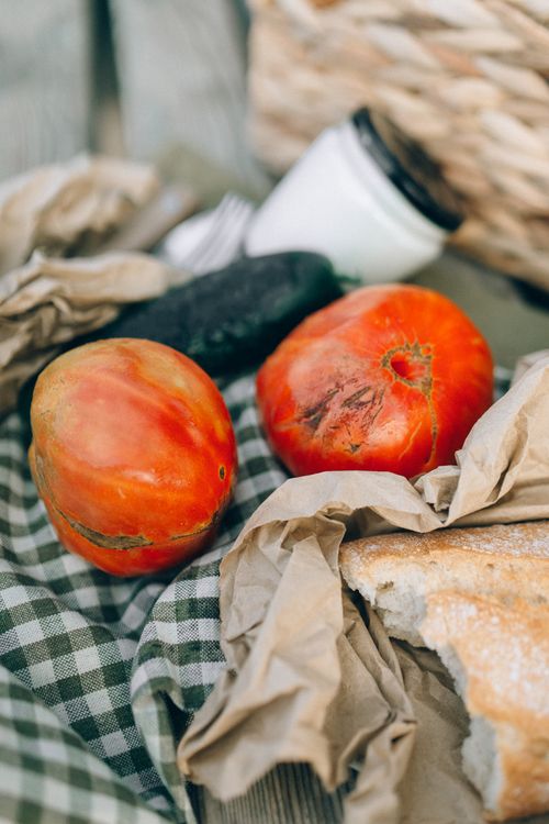 Free Fresh tomatoes and bread on a rustic table setting, perfect for a farm-to-table theme. Stock Photo