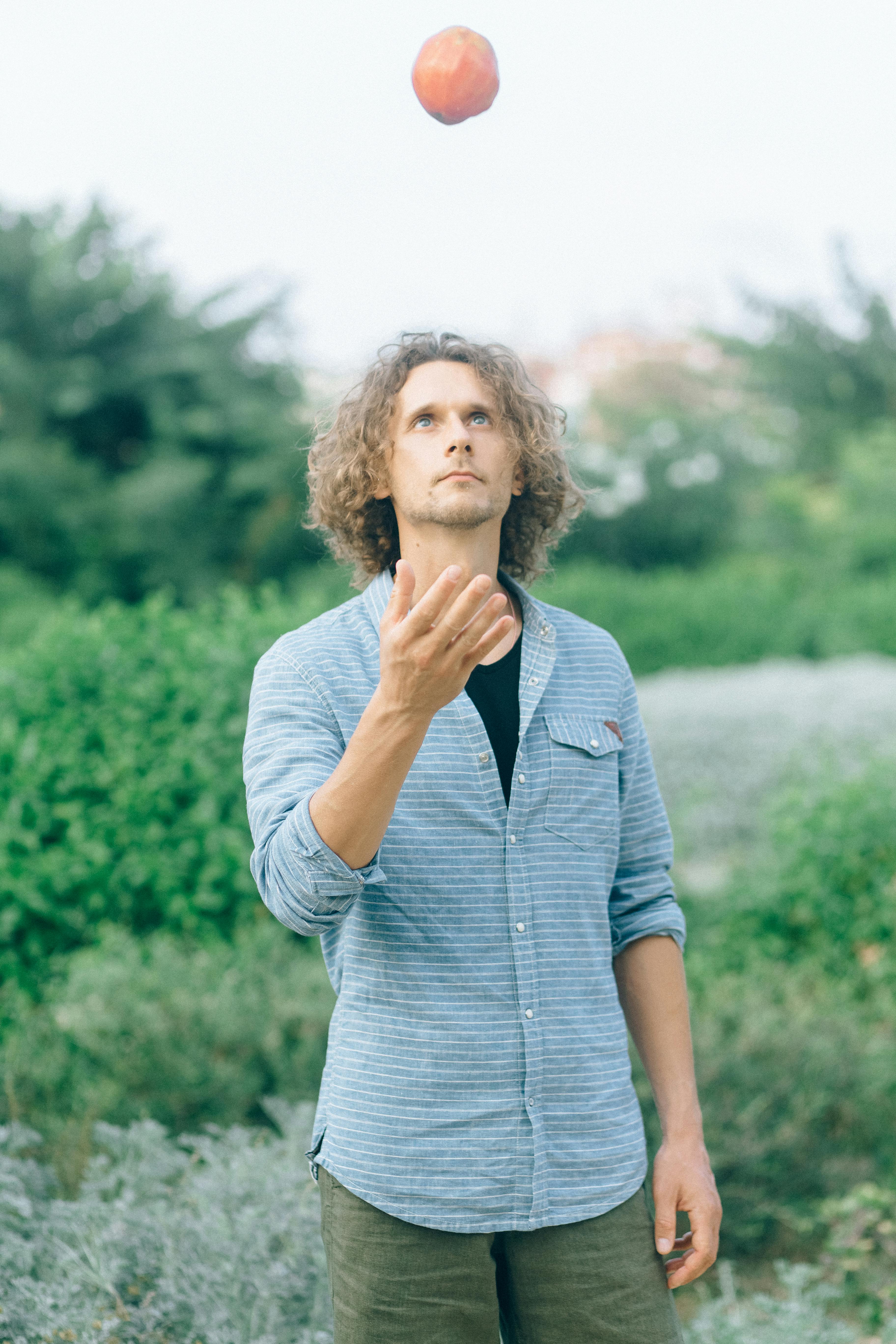 woman in blue denim button up jacket standing near green trees