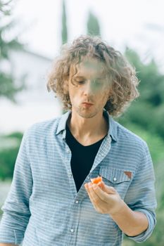 年轻人在花园里品尝新鲜的番茄，这是健康或生活方式主题的理想选择