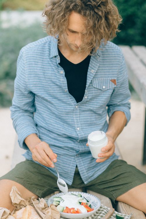 Free A young caucasian man prepares and enjoys a healthy salad on a summer day. Stock Photo