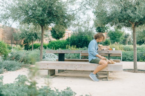 A Man Sitting on the Wooden Picnic Table