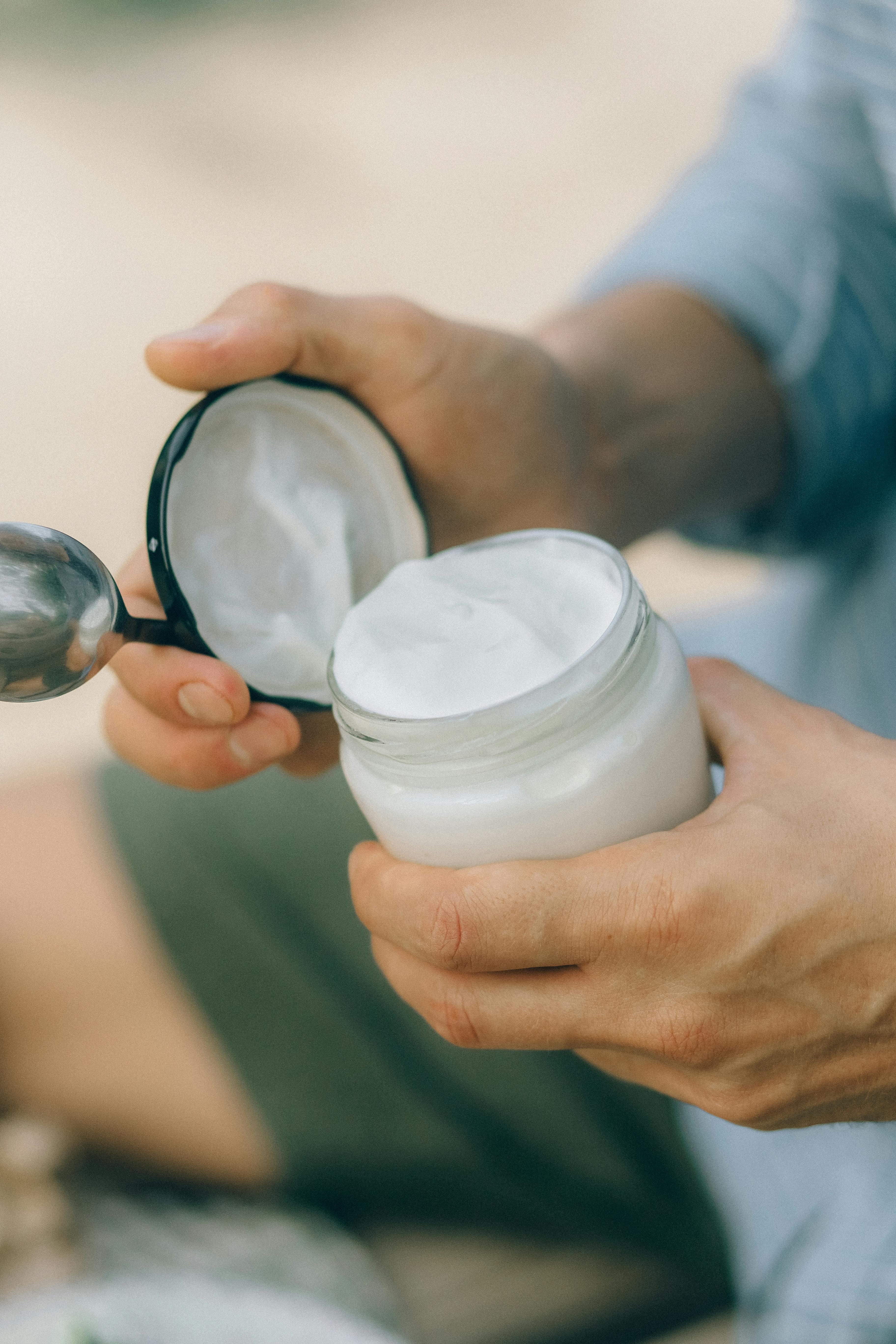 person holding white round container