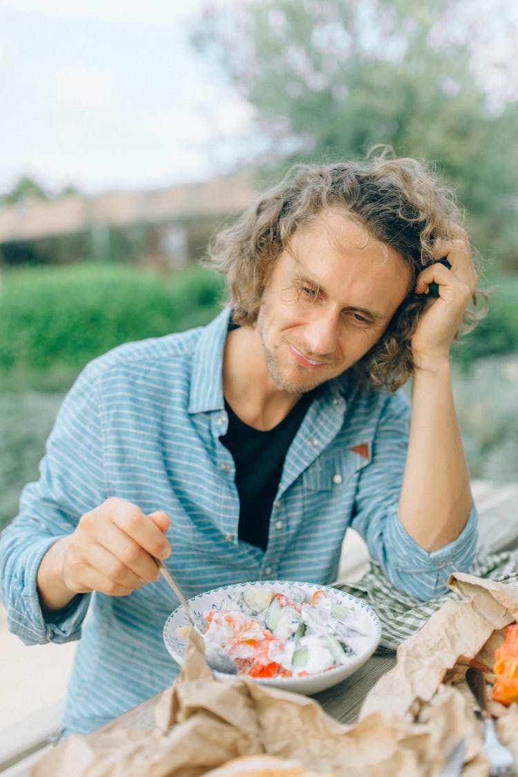 A Man Eating Salad In A Bowl