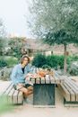 Woman in Gray Jacket Sitting on Brown Wooden Bench