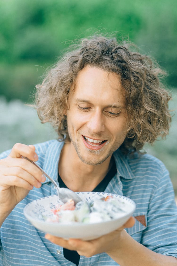 Man Eating A Bowl Of Salad