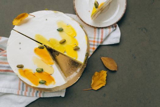 A top view of a beautifully decorated pistachio cake with autumn leaves and colorful icing, perfect for seasonal moods.