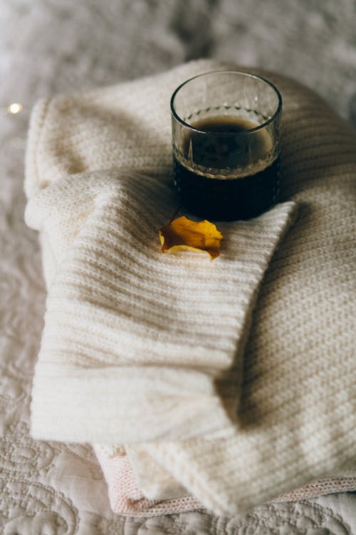 Clear Drinking Glass on Top of Knitted Sweater 