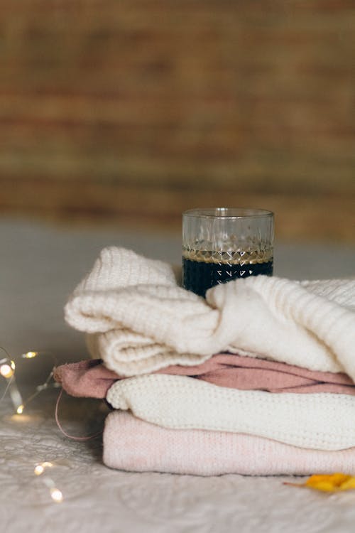 Free Clear Drinking Glass on Top of Knitted Sweater Stock Photo