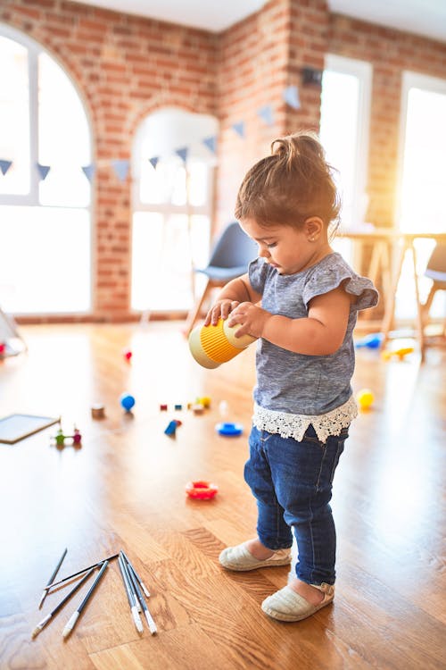 Free Little Girl Playing with Toys Inside a Playroom Stock Photo