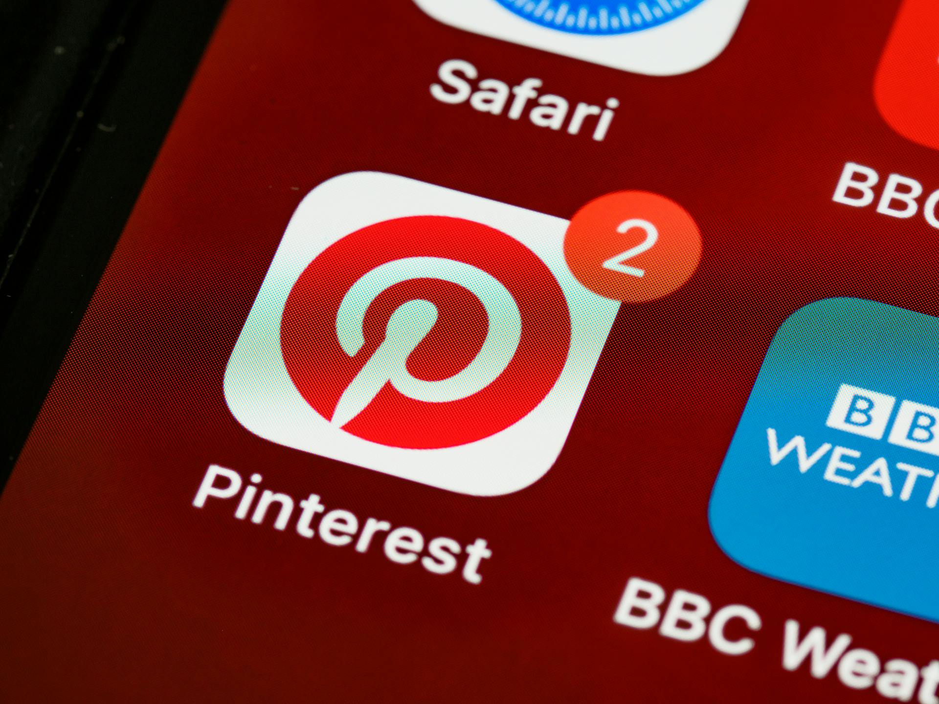 Close-up of Pinterest app icon and notifications on a smartphone screen, detailed and vibrant technologically themed image.