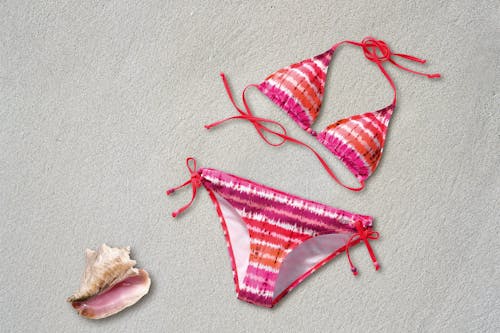 Bộ Bikini Sọc Trắng Màu Cam Hồng Gần Vỏ Trên Bãi Biển Cát