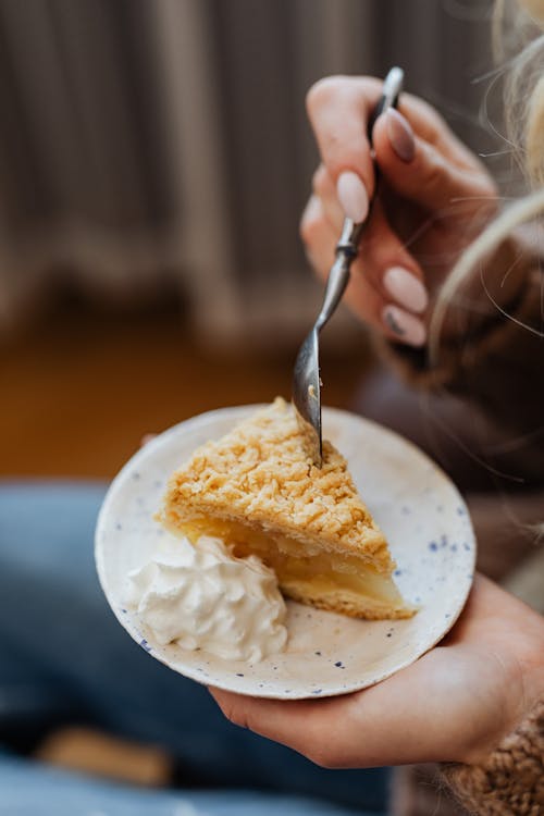 Close-up of Woman Eating a Slice of Apple Pie with Whipped Cream 