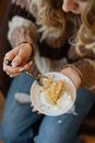 Woman in White Long Sleeve Shirt Holding Silver Fork With White Cream
