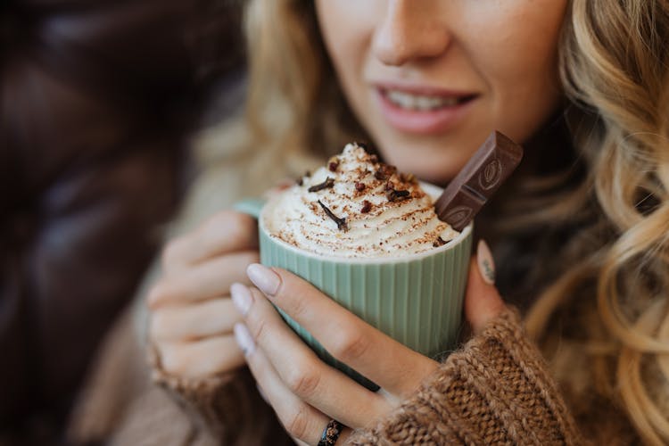 A Woman Holding A Cup Of Hot Cocoa