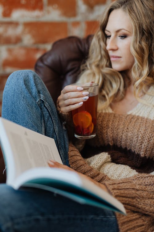 Free Woman in Brown Sweater Holding Clear Drinking Glass Stock Photo