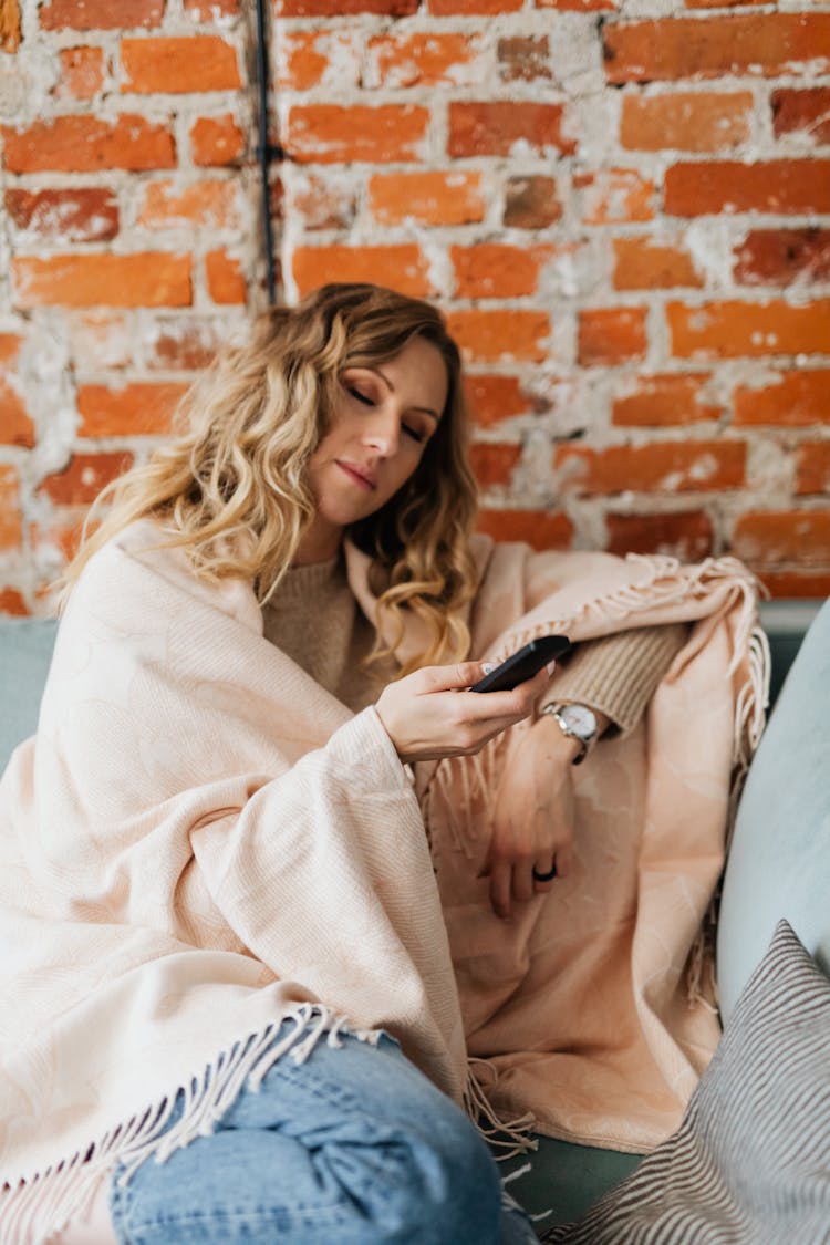 Woman Wrapped In A Blanket Relaxing On A Sofa 