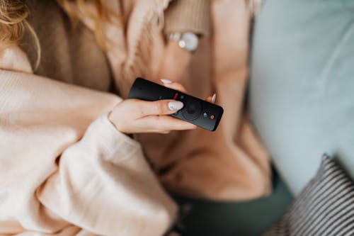 A Person Holding a Black Remote Control