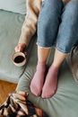 A Person Holding a Cup of Coffee While Sitting on a Couch