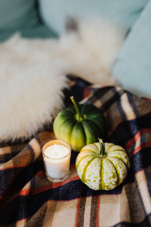 Small Pumpkins Beside Lighted Candle