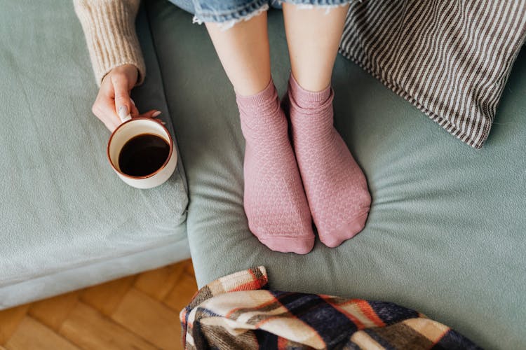 Coffee Cup And Feet On Sofa