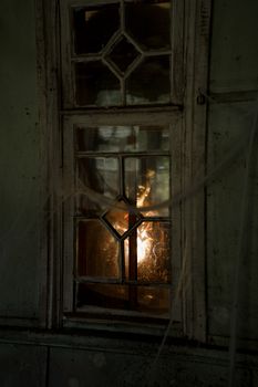 一束神秘的光芒照亮了废弃建筑的窗户，营造出令人毛骨悚然的氛围