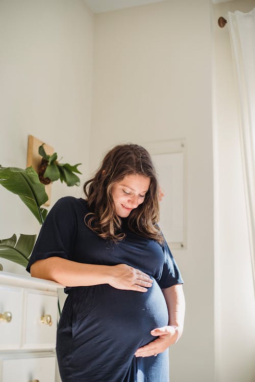 Frohe Schwangere Frau, Die Bauch Im Hauszimmer Streichelt