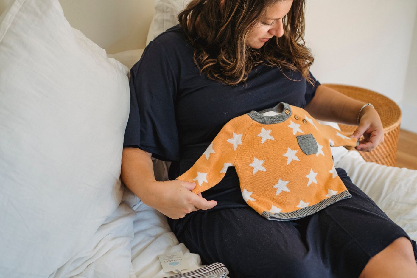 Future maman préparant les petits vêtements de naissance pour sa valise de maternité