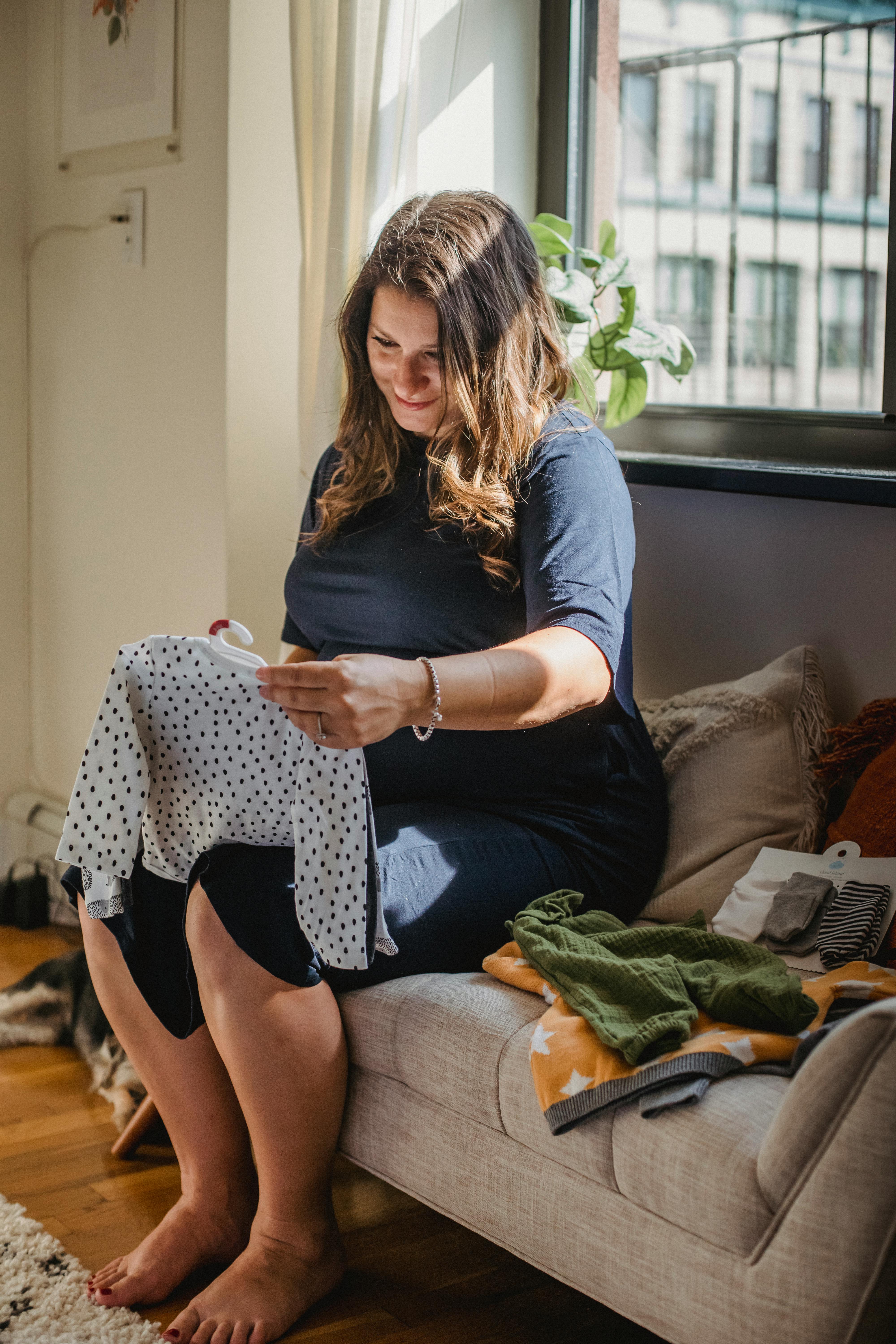 woman choosing apparel for newborn baby