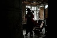 Man in Black Jacket and Black Pants Standing Inside Abandoned Building