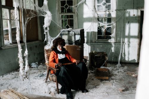 Free Scary clown in an abandoned, cobweb-filled room, perfect for Halloween scenes. Stock Photo
