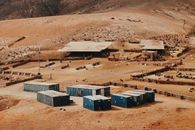 White and Blue Houses on Brown Field