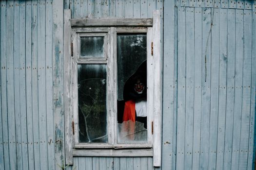 Person in Black Hoodie Standing in Front of Window