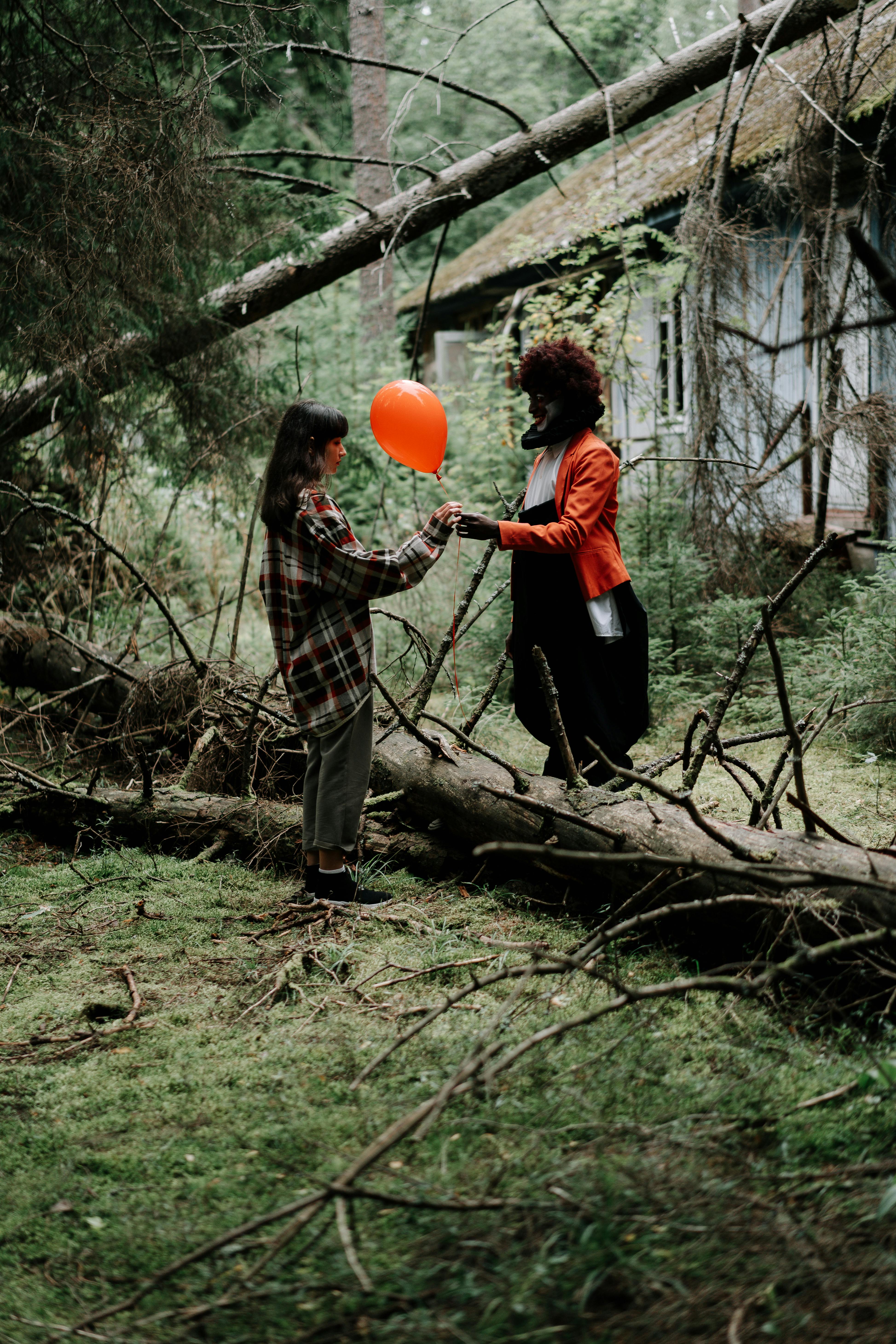 girl receiving a balloon from a scary clown