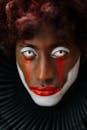 一张以大胆红白配色为特色、呈现戏剧性万圣节外观的小丑肖像特写