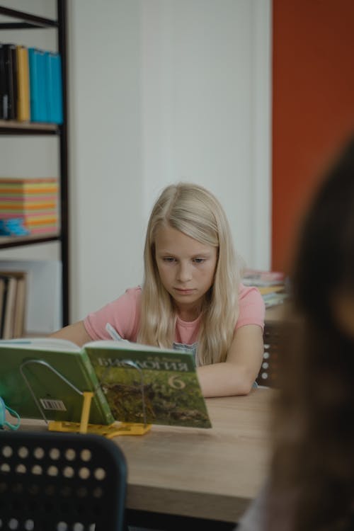 Girl Taking Notes while Reading a Book