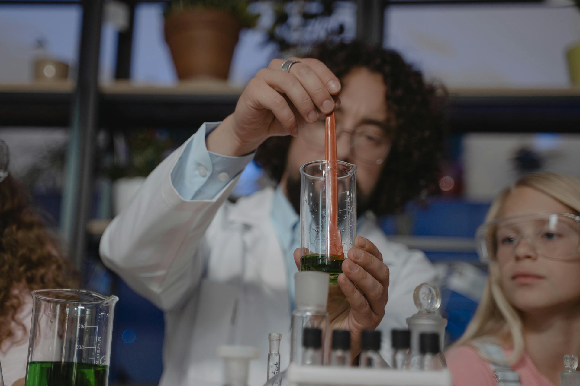 Teacher Mixing a Colored Liquid inside a Beaker