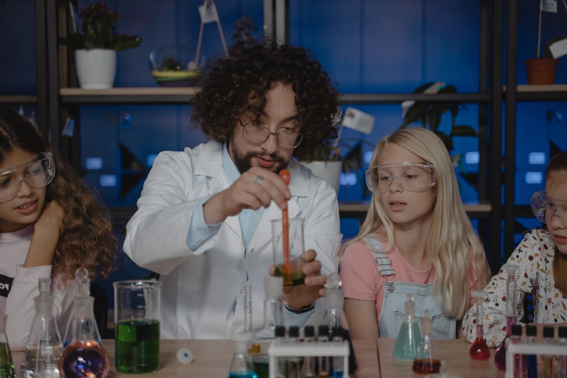 Free Teacher Mixing a Colored Liquid inside a Beaker
 Stock Photo