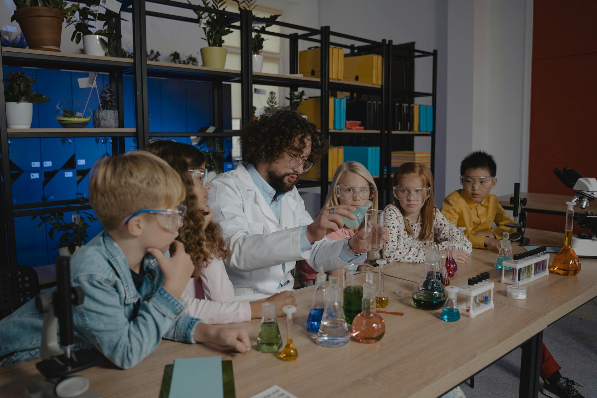 Students explore chemistry experiments with a teacher guiding them in a classroom.