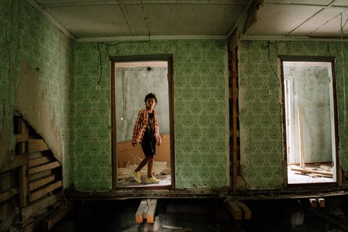 Free A teenager explores a decrepit, eerie room in an abandoned building, adding a sense of mystery and adventure. Stock Photo