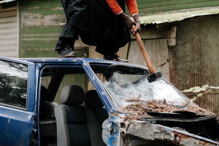 Person Smashing Car Windshield With A Sledge Hammer