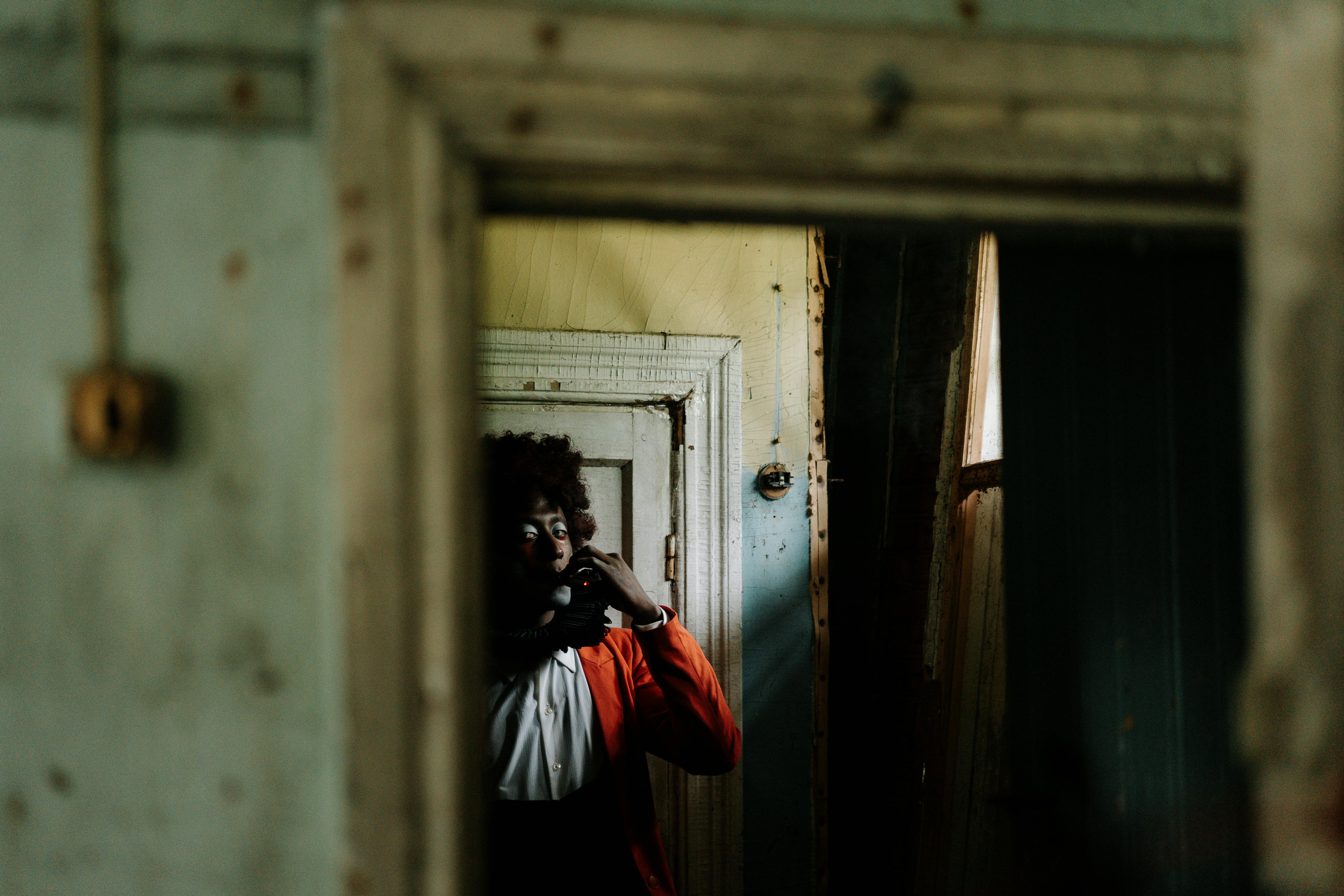 spooky clown smoking inside an abandoned building