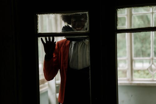 Spooky Clown Standing behind a Glass Door