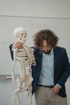 Teacher Standing beside a Human Skeleton