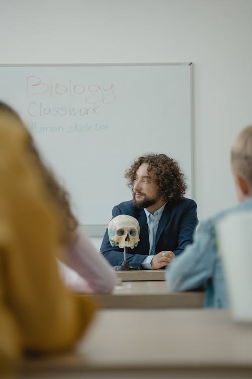 A Teacher Sitting in front of a Class