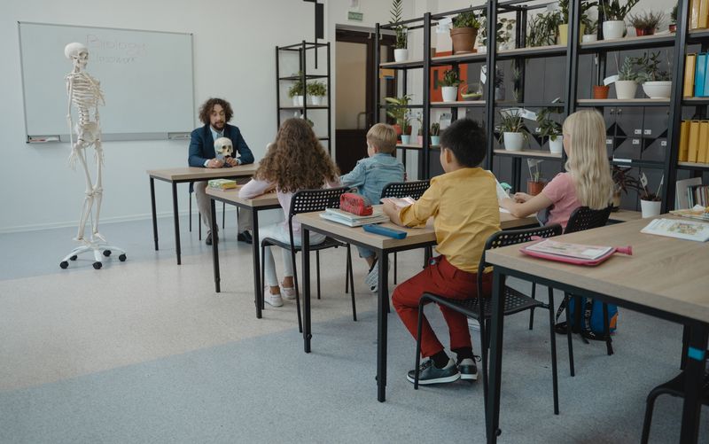 Children learning biology with a skeleton model