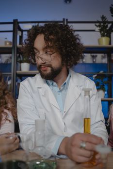 在实验室里，一位卷发专家科学家穿着白大褂分析试管