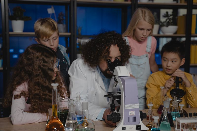 Students observe as a teacher conducts a chemistry experiment