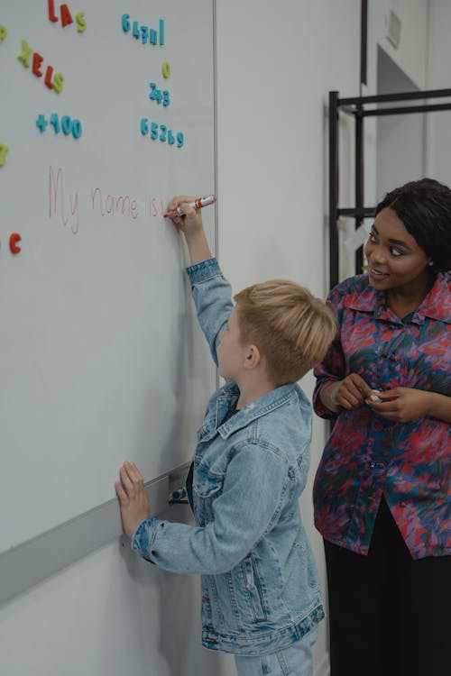 Student Writing on Whiteboard using a Red Marker