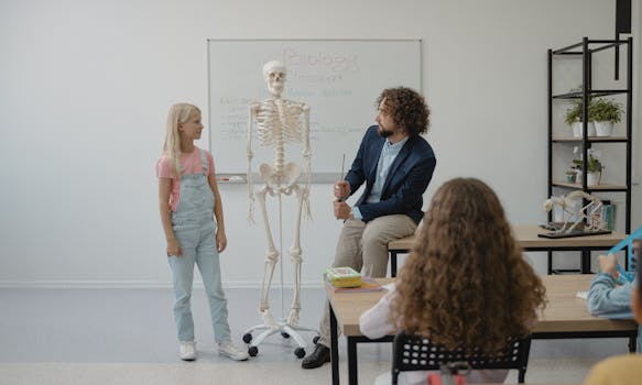 Teacher and students in a classroom using a skeleton model for a biology lesson.