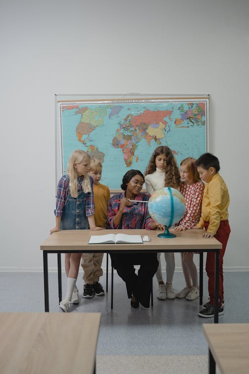 Teacher teaching students about Geography using a Globe 